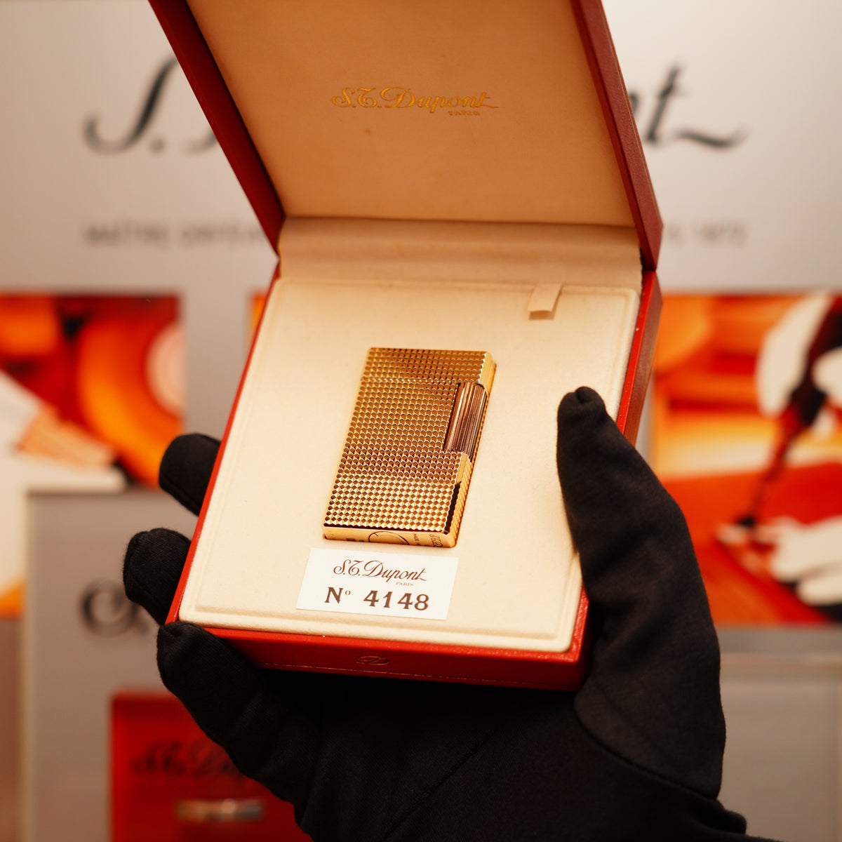 A gloved hand holds an open red S.T. Dupont box displaying a Vintage 1990 St Dupont 24k Gold Iconic Ligne 1 lighter, featuring a Diamond Head Pattern, labeled No. 4148.