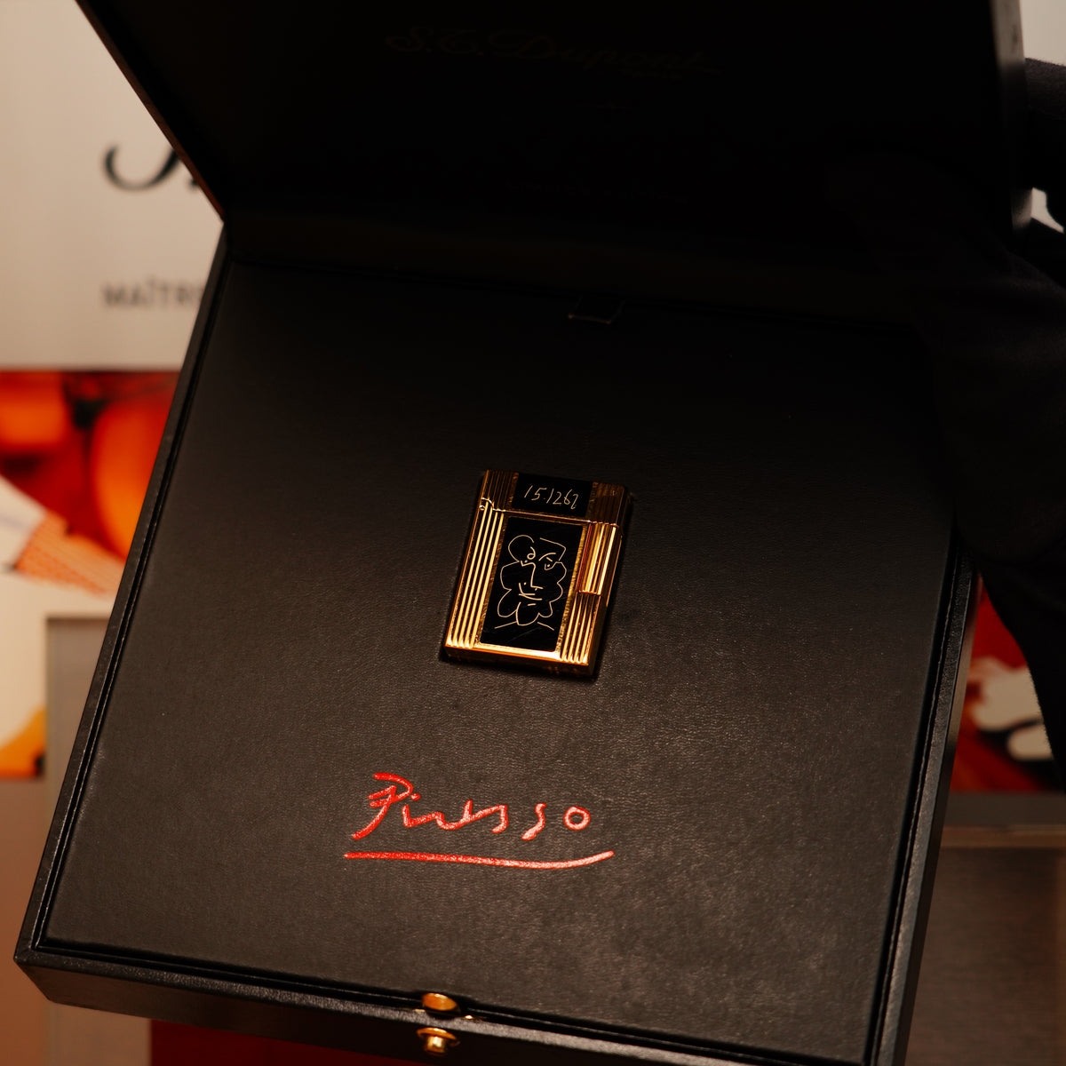 S.T. Dupont's Vintage 1990 Ligne 1 black lacquer lighter features a 24k gold finish and is presented in an open black box with "Picasso" inscribed inside.