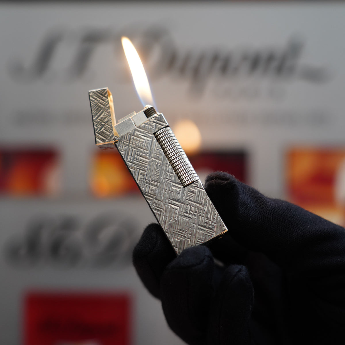 A person is holding a Vintage 1980 Dunhill Rollagas Silver Plated Florentine Pattern Lighter in their hand.