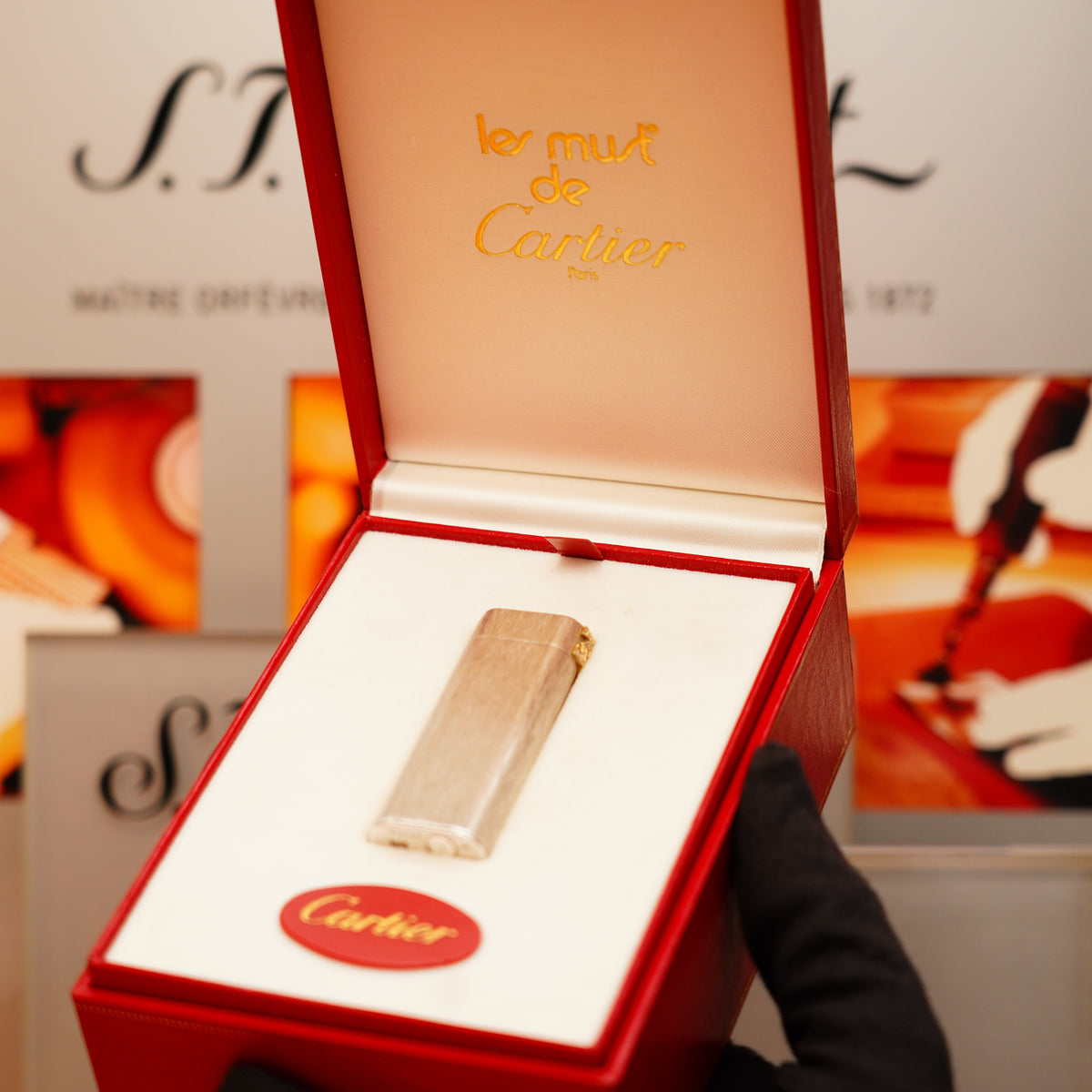 The Vintage 1970 Extremely Rare Cartier Solid 925 Sterling Double C solid 18k with 16 Natural Cartier Diamond Set Lighter is showcased in an open red box lined with white fabric.