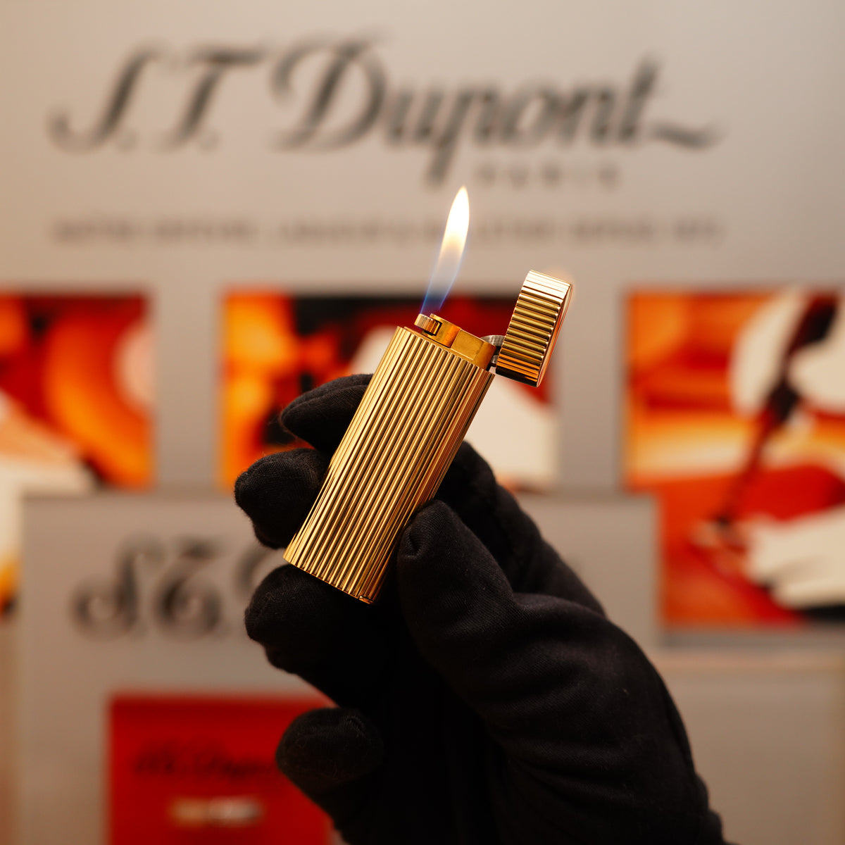 A gloved hand holds a lit Vintage 1970 Extremely Rare Cartier Solid 18k Gold Vertical Line Heavy Lighter against a blurred background featuring the Cartier logo.