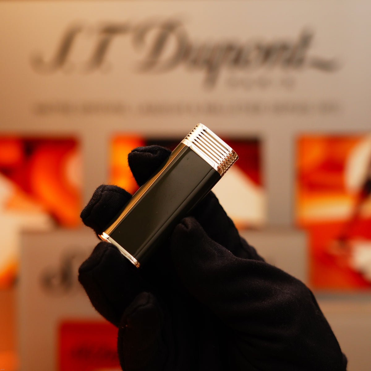 A gloved hand holds the Vintage 1970 Extremely Rare Cartier Solid 925 Sterling Silver Natural Full Dark Green Lacquer Rare Lighter from KirbyAllison.com against a blurred display background.