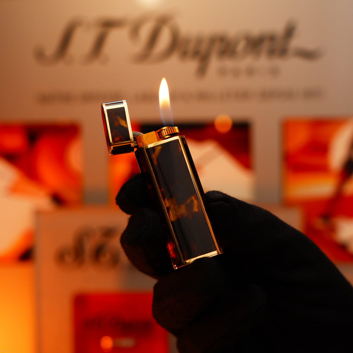 A gloved hand holds the Vintage 1970 Limited Cartier Solid 18K Gold Tiger’s Eye Resin Lighter by Lucy Lighter, its flame glowing—an extremely rare, heavyweight collectible marked 750 and 1/1, embodying true luxury and elegance.