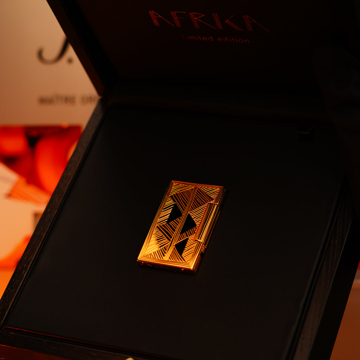 The Lucy Lighter Vintage 2000 St Dupont Limited Edition Africa Natural Lacquer Large Ligne 2 Lighter features a heavy 24k gold finish, geometric patterns, comes in a black box, and includes a 12-month warranty.