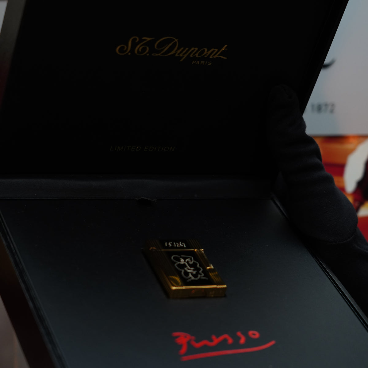 A black box presents a Vintage 1990 Important S.T. Dupont Ligne 1 lighter, featuring a luxurious 24k gold finish and black lacquer with an exclusive design and signature from the Pablo Picasso Limited Edition.