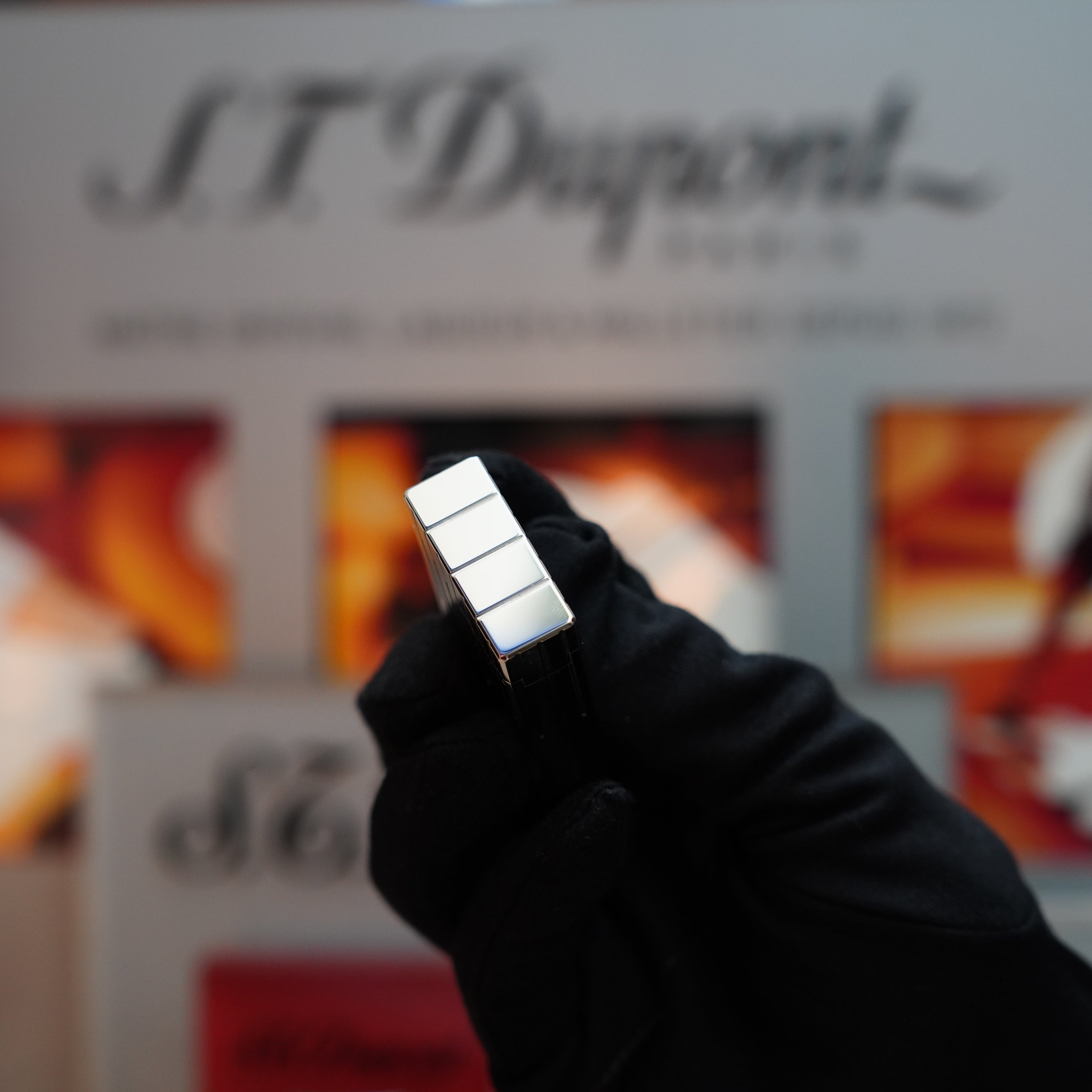 A gloved hand holding a Vintage 1999 S.T. Dupont Rare Perspective 2000 Palladium Limited Edition Ligne 1 Lighter with its sleek finish.