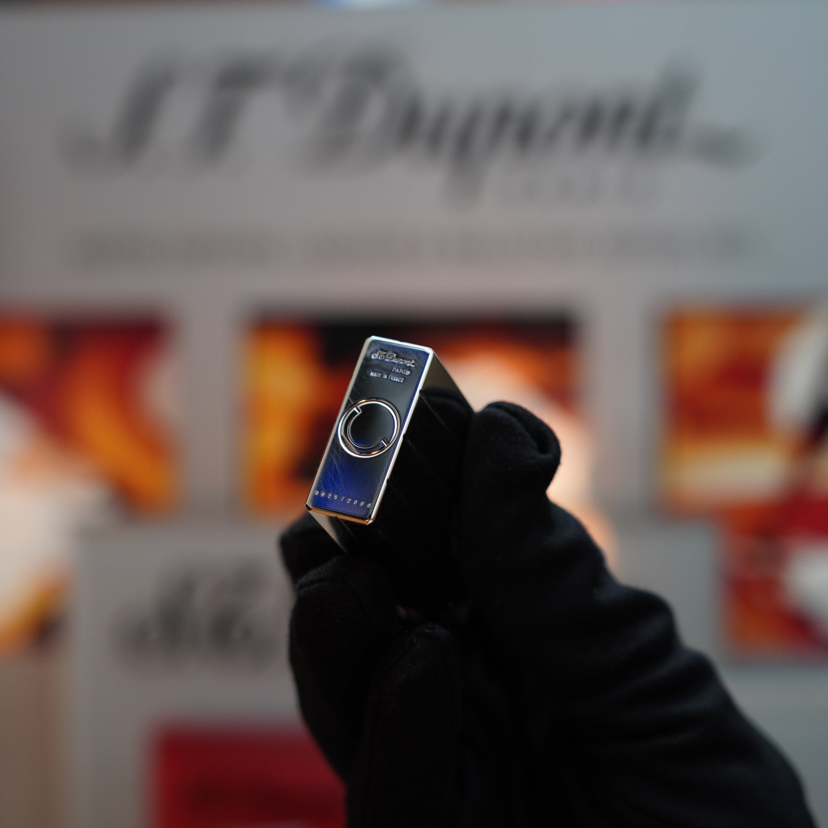 A gloved hand holds a sleek, metallic USB drive with branding visible, reminiscent of the elegance found in an S.T. Dupont Vintage 1999 Rare Perspective 2000 Palladium Limited Edition Ligne 1 lighter, set against a blurred background.