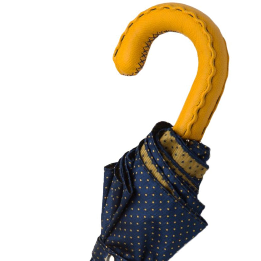 A Navy Yellow-Dot Travel umbrella with a yellow leather handle from KirbyAllison.com.