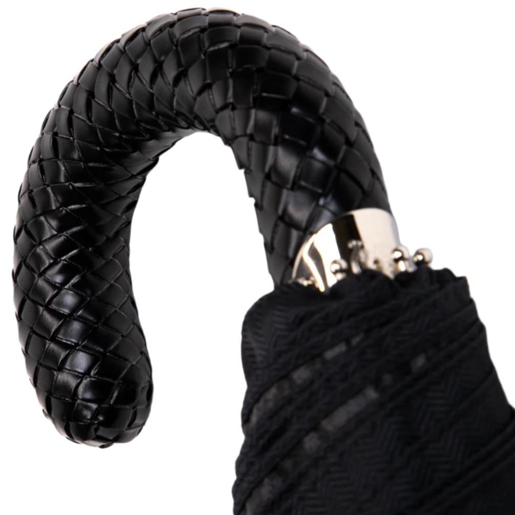 A KirbyAllison.com Black Herringbone Canopy Travel Umbrella with a Woven Leather Handle.
