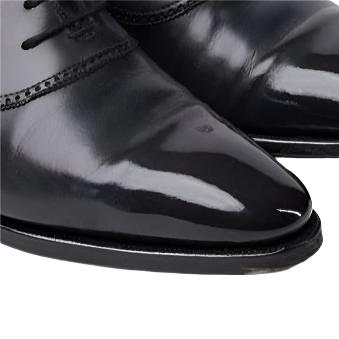 A pair of black oxford shoes on a white background showcasing the KirbyAllison.com Presidential Shoe Shine Service.