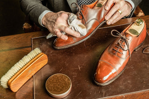 A pair of shoes being polished with brown Saphir Mirror Gloss