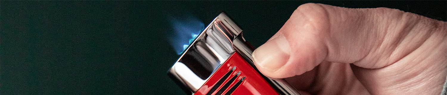 S.T. Dupont Paris logo on a dark, blurred background with golden hues.