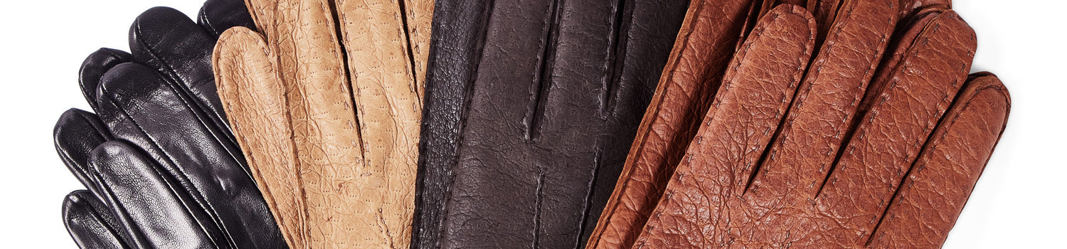 A row of different colored leather gloves on a white background.