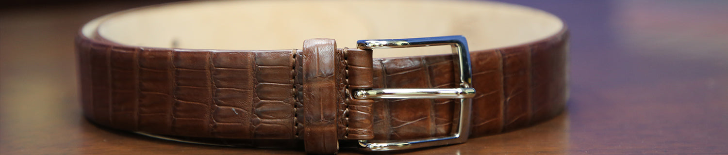 Photograph of a Sovereign Grade brown crocodile belt with a chrome buckle. 