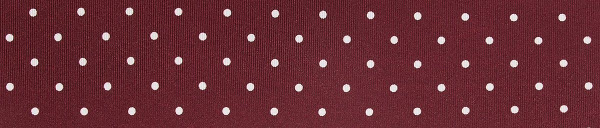 Maroon fabric with a white polka dot pattern.