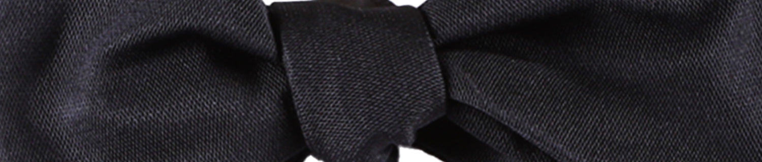 Close-up of a black fabric bow tie.