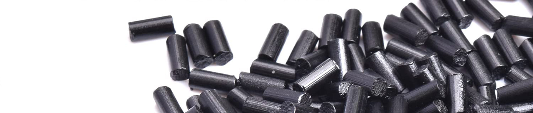A pile of small, cylindrical black pellets scattered on a white surface.