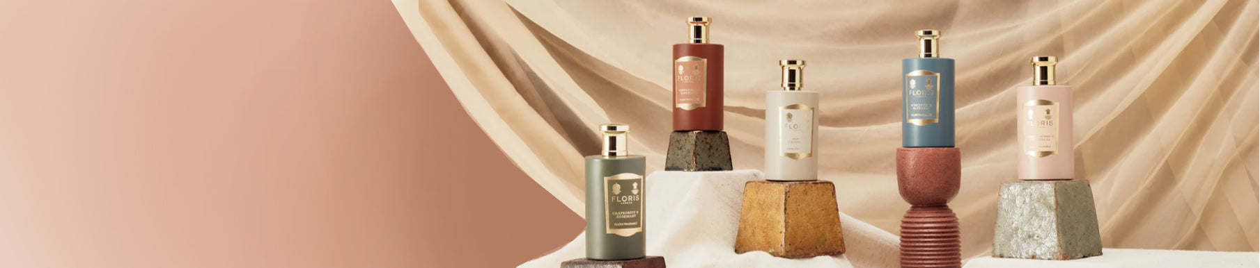 Three perfume bottles with Floris labels, placed on a shelf next to a framed painting.