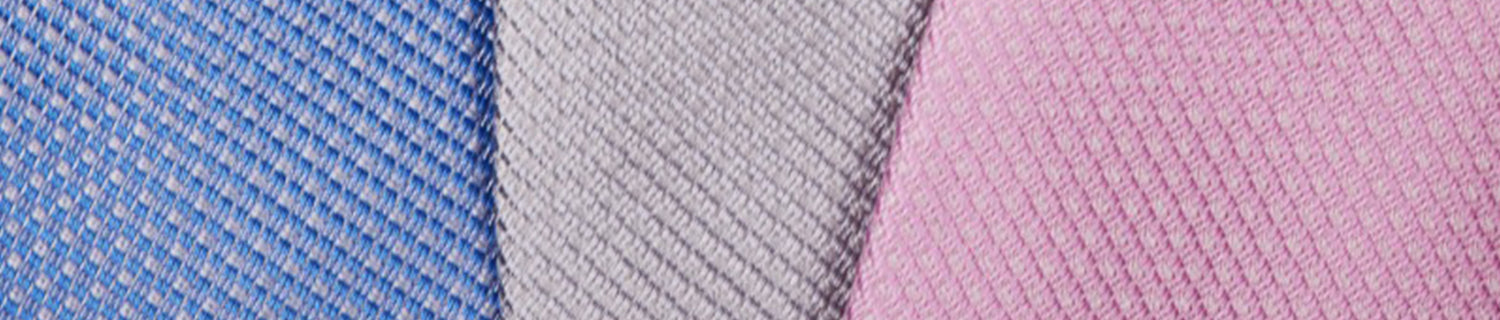 Close-up of three textured fabric swatches in blue, gray, and pink arranged side by side.