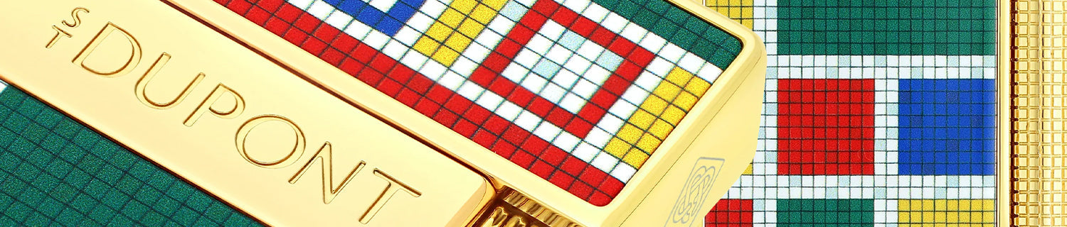 Close-up of colorful, geometric patterned objects with gold accents, featuring the embossed brand name "S.T. Dupont.