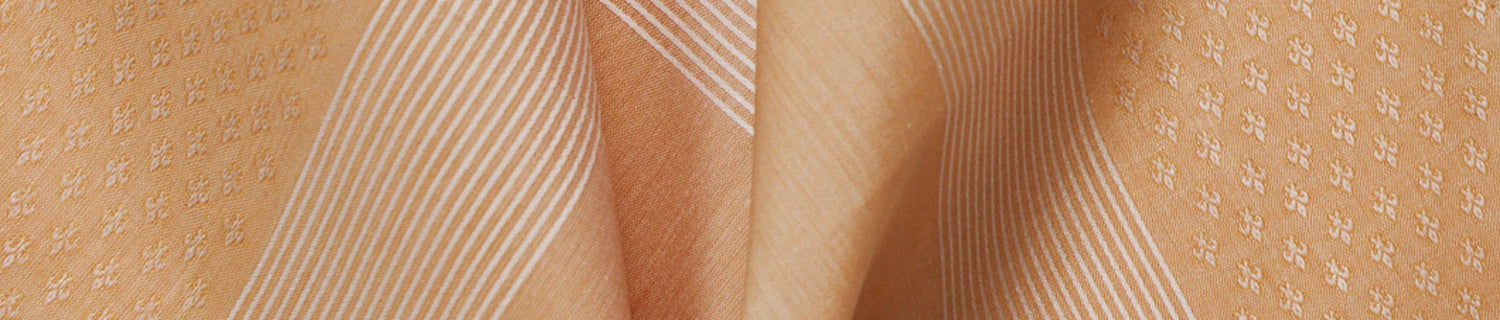 Two woven fabric patterns side by side: left is pale yellow with diagonal stripes, right is brown with small floral motifs.