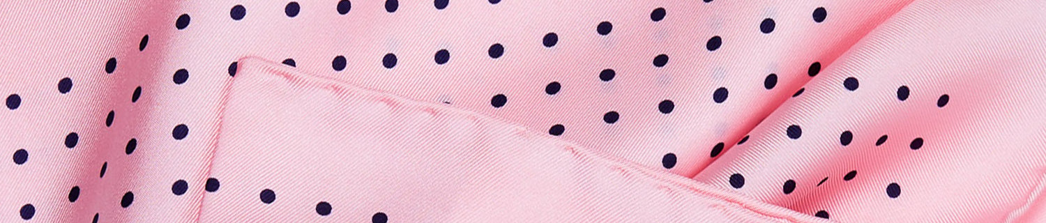 Close-up of pink fabric with navy polka dots.