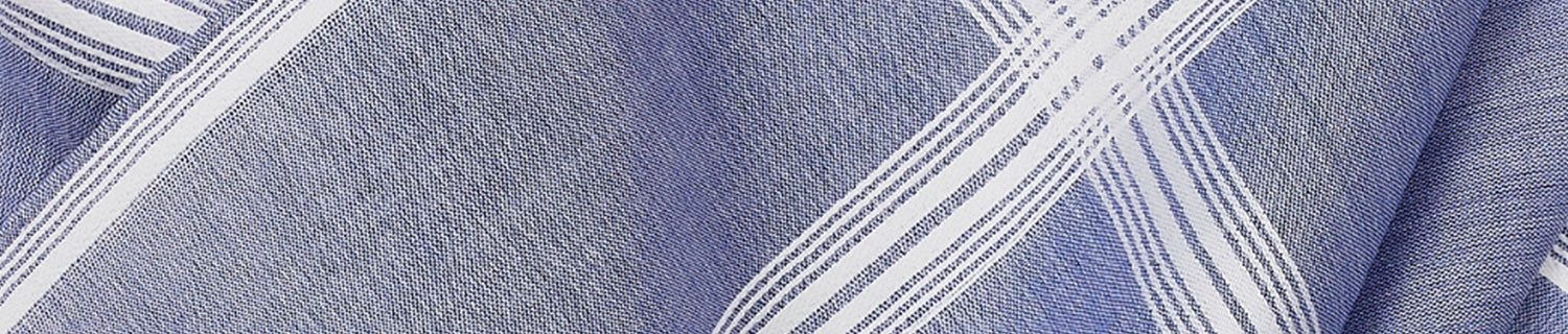 Close-up of a blue and white plaid fabric with diagonal and vertical lines creating a geometric pattern.