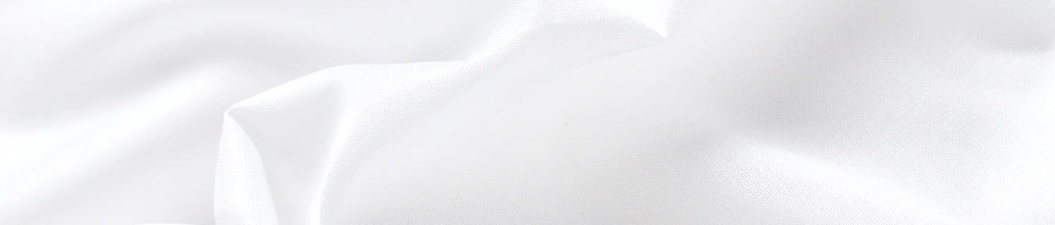 Close-up of white fabric with gentle folds and a smooth texture.