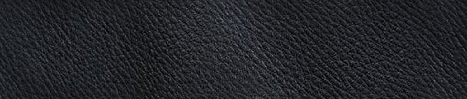 A pair of black shoes and a brush on a black surface.