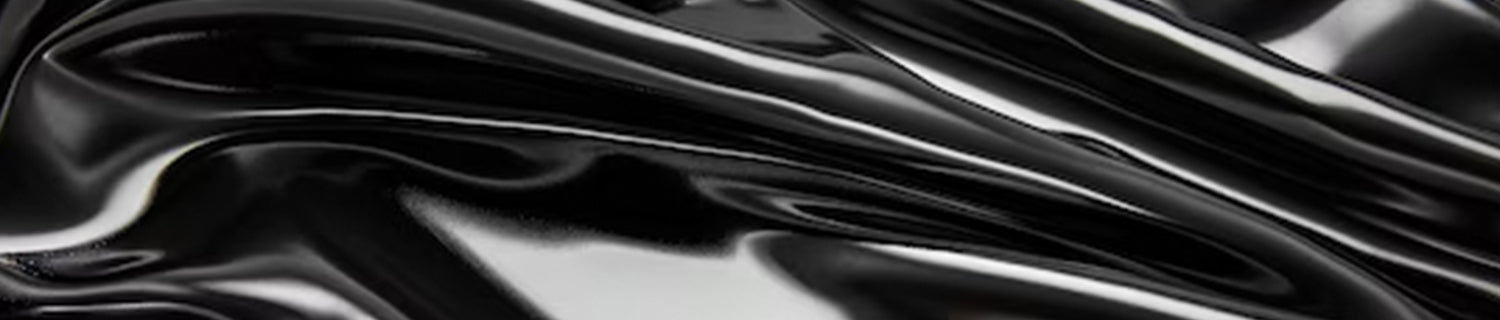 A pair of black shoes and a brush on a black surface.