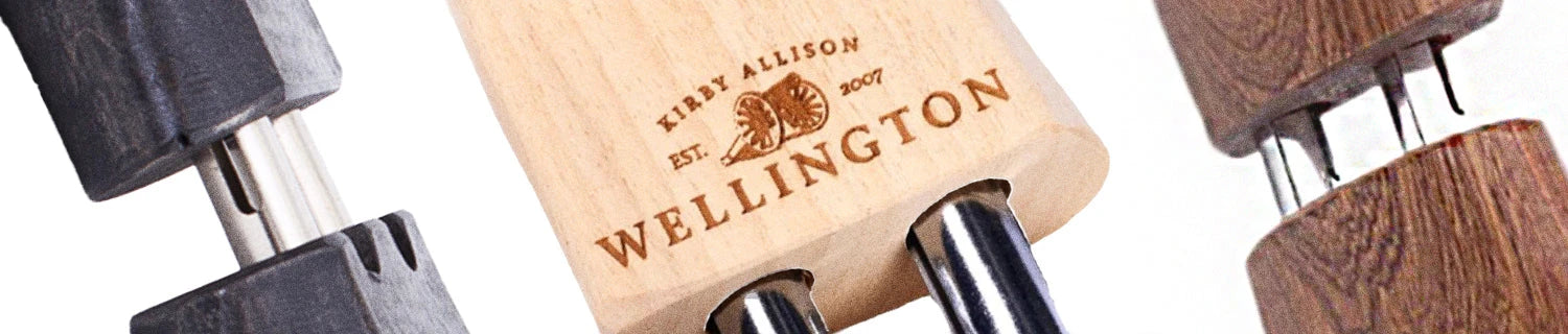 Polished black dress shoes with laces, alongside shoe care products and a brush on a dark surface.