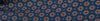 Close-up of fabric with a repeating geometric pattern featuring orange and blue shapes on a dark background.