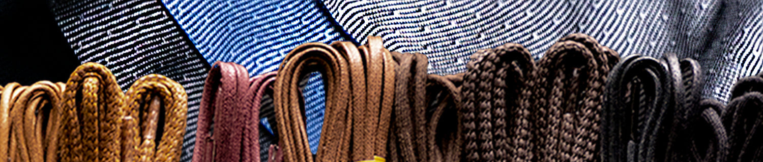 Close-up of an assortment of colorful shoe laces displayed in rows.