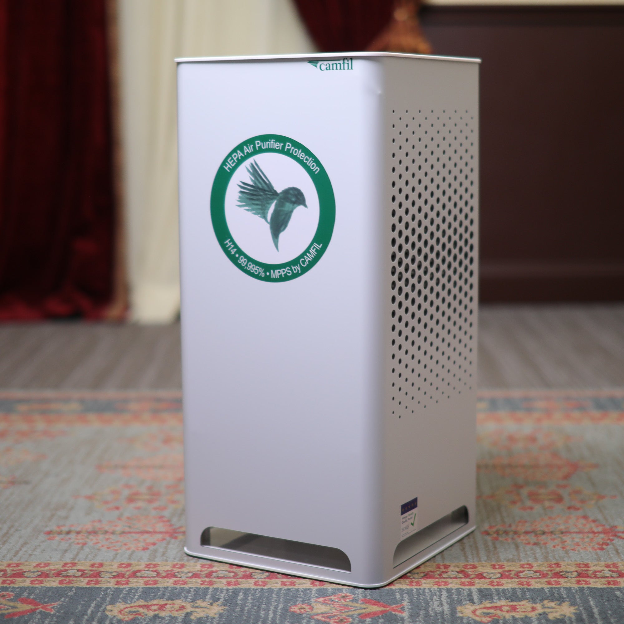 A CamFil CityM HEPA 250 CFM Air and Smoke Filter sitting on a rug in a room.