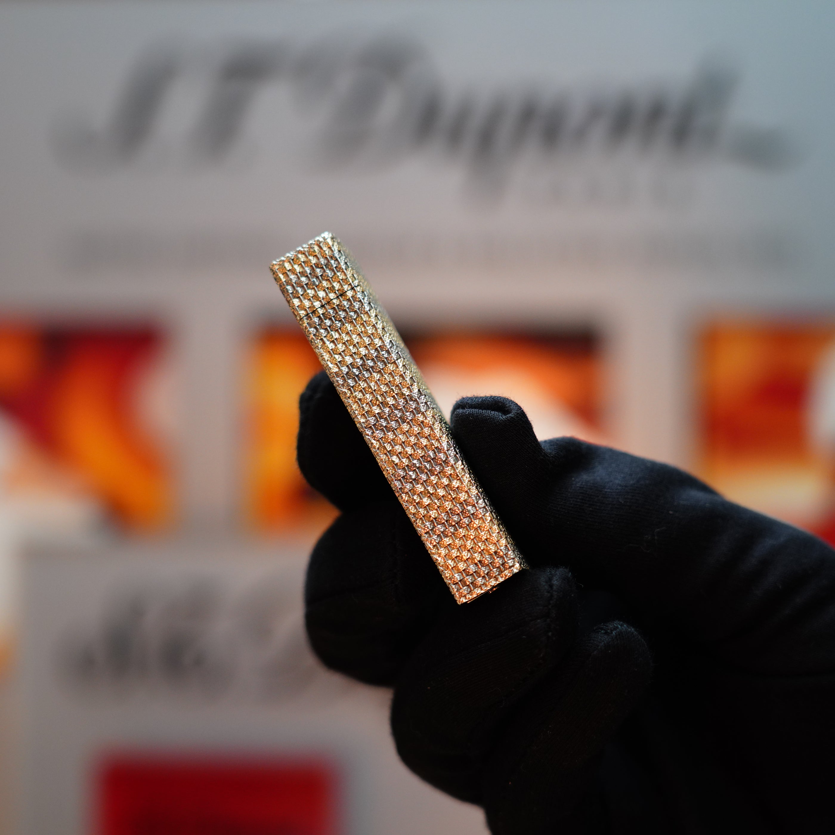 A gloved hand holds a pentagon-shaped, solid 18k gold Vintage 1978 Cartier lighter from the Rare Basket series, featuring 750 hallmarks.