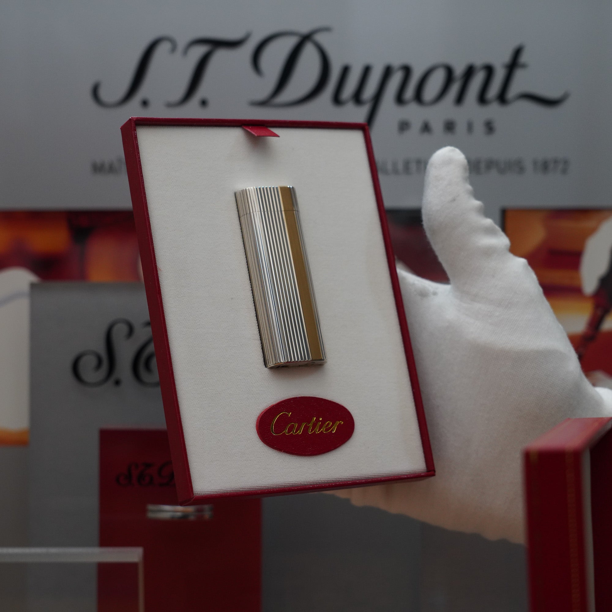 A person is holding a vintage box with a Cartier St Dumont logo.