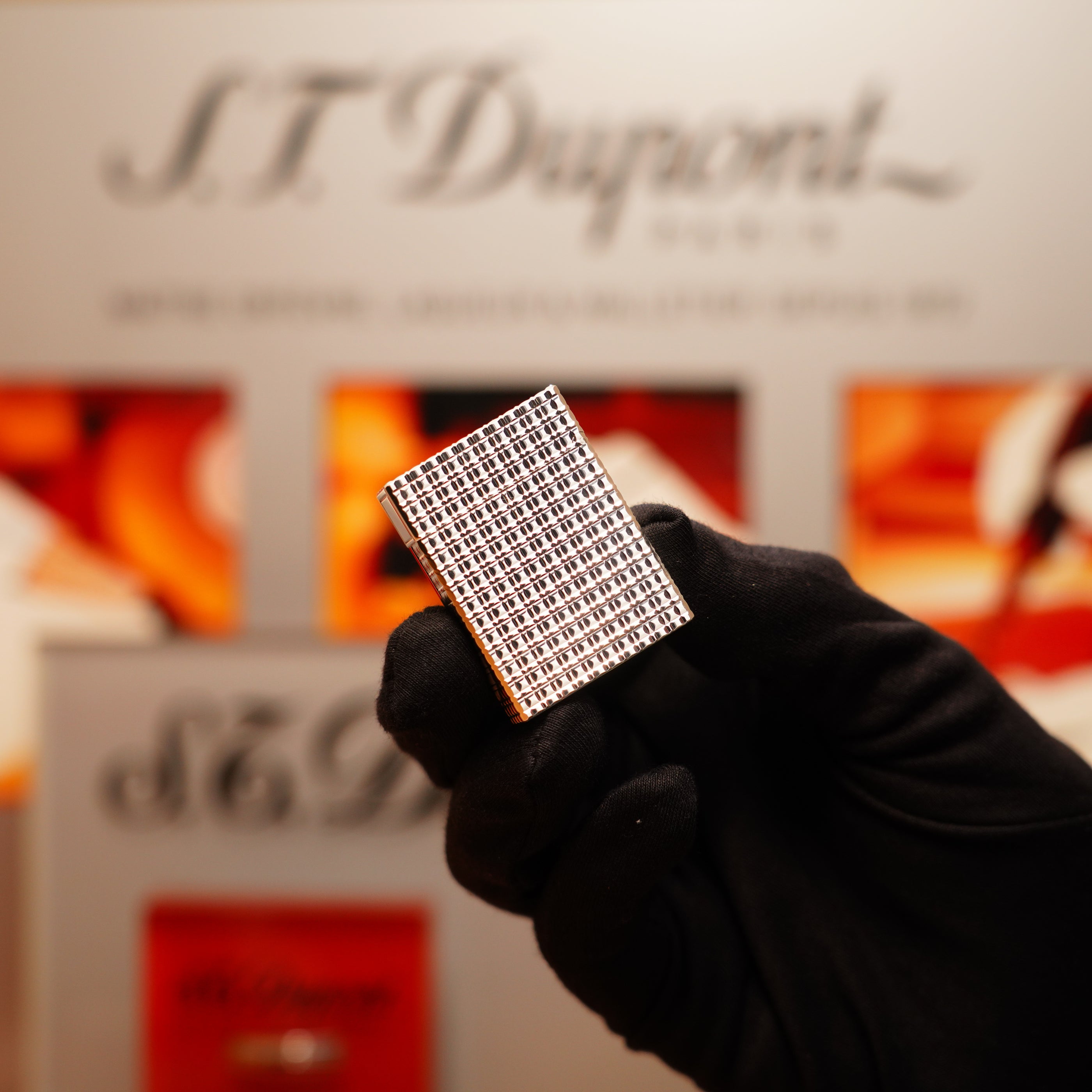 A gloved hand holds a Vintage 1990 S.T. Dupont Ligne 1 Rare Window Pattern Lighter with silver finish, the branding subtly blurred in the background.