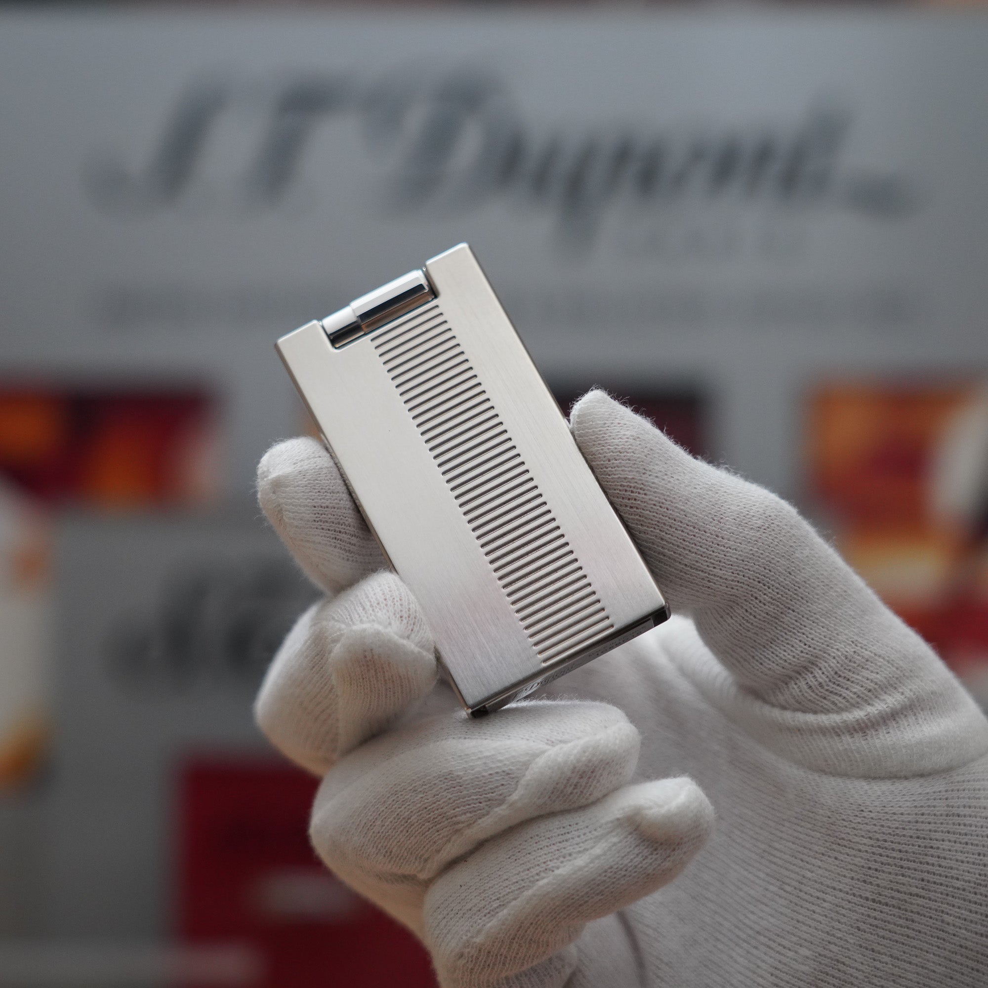 A person is holding a Vintage 2000 S.T. Dupont Palladium Décor High Tech 2000s Lighter.