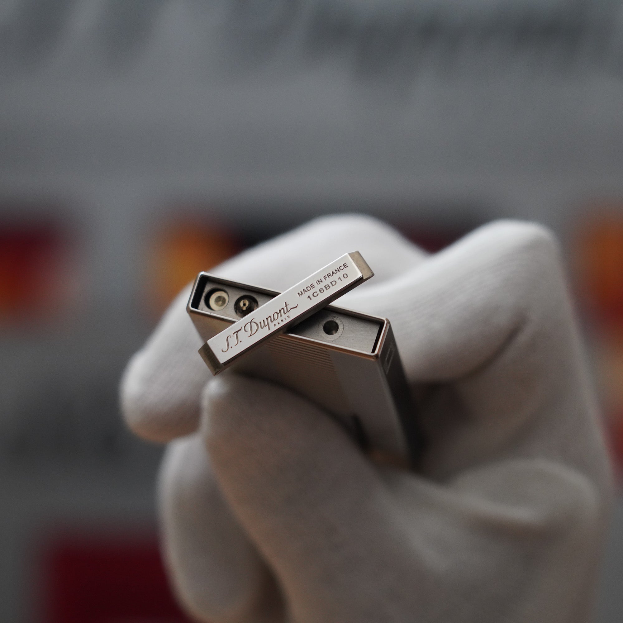 A person holding a S.T. Dupont Vintage 2000 Palladium Décor High Tech 2000s Lighter in their hand.