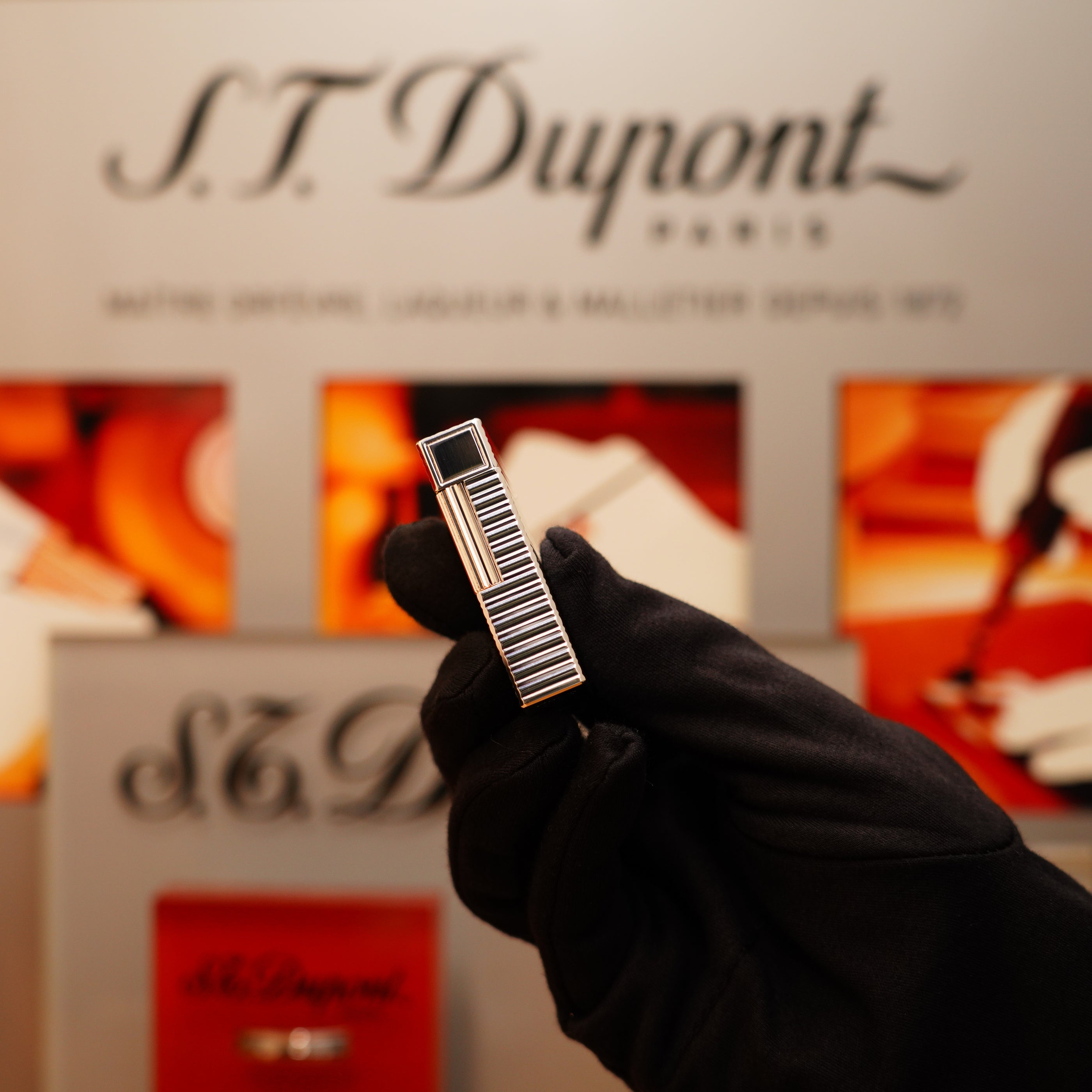 A gloved hand holds a sleek, metallic S.T. Dupont lighter featuring the Vintage 1990 Large Heavy Silver Finish Ligne 1 Horizontal Pattern design.