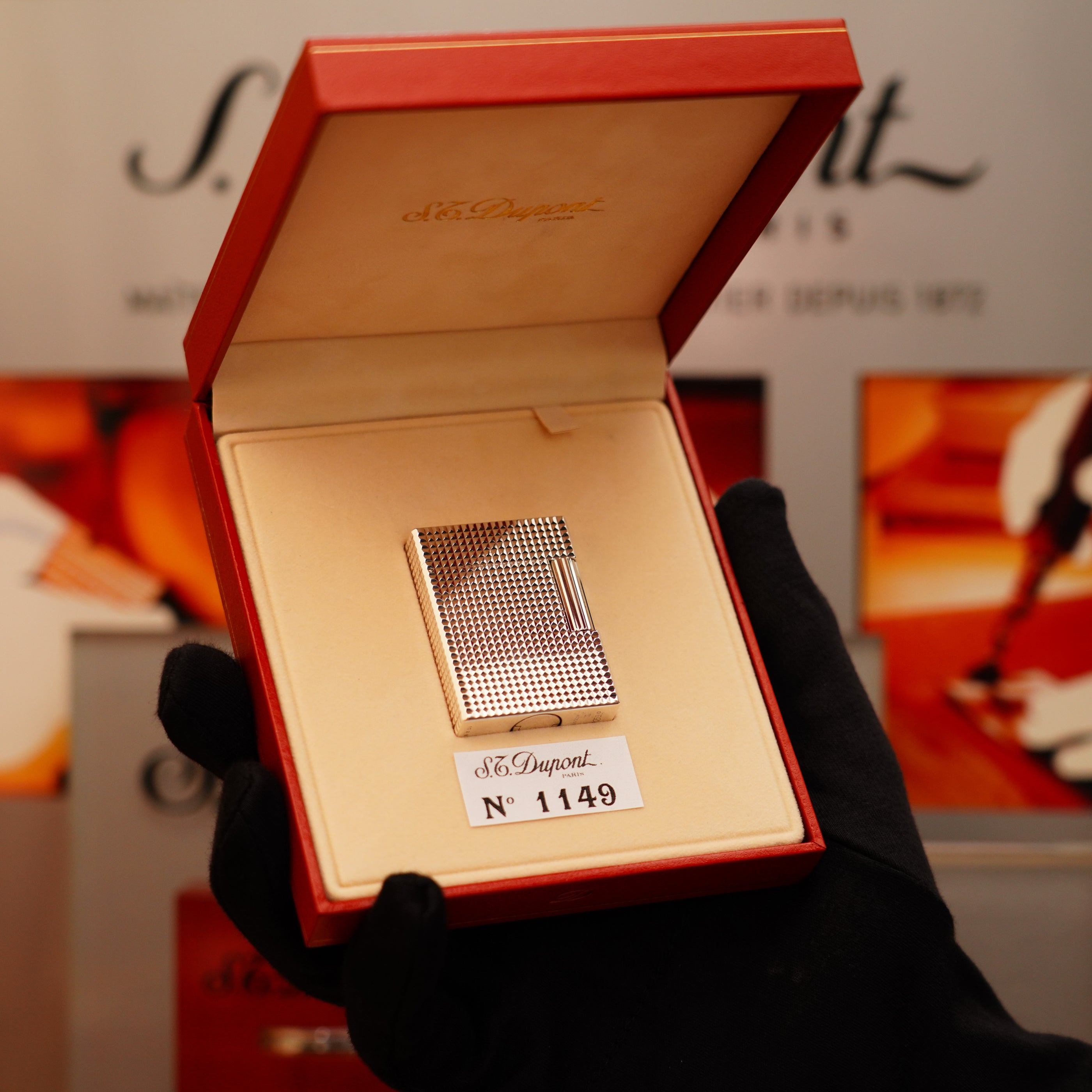 A gloved hand holds an open red box containing a Vintage 1996 St Dupont Ligne 1 Diamond Head Pattern small Heavy Silver Finish Lighter, labeled "S.T. Dupont" and marked with the number 1149.