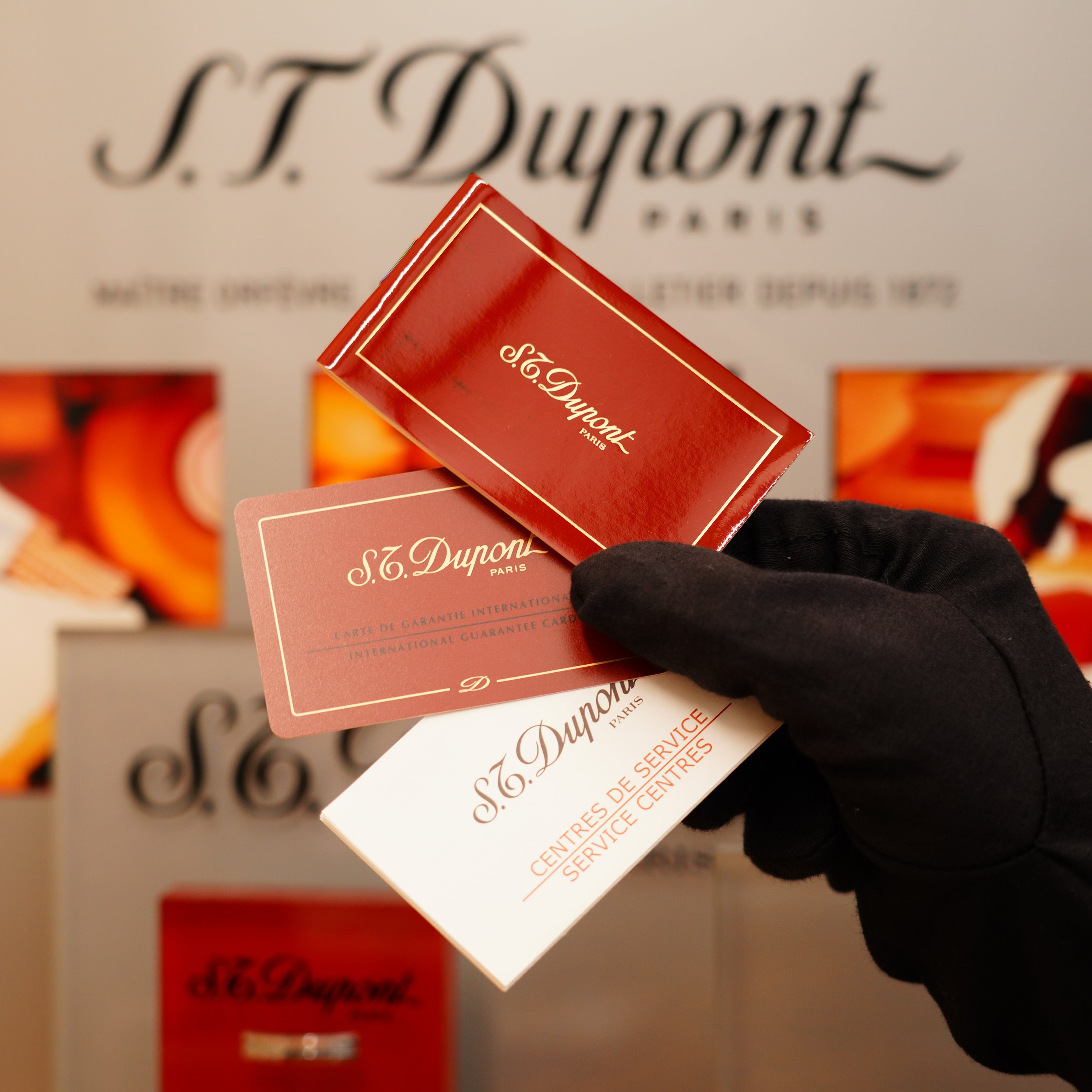 A gloved hand holds S.T. Dupont cards against a backdrop featuring the Vintage 1996 St Dupont Ligne 1 Lighter with a rare heavy silver finish and vertical line pattern.