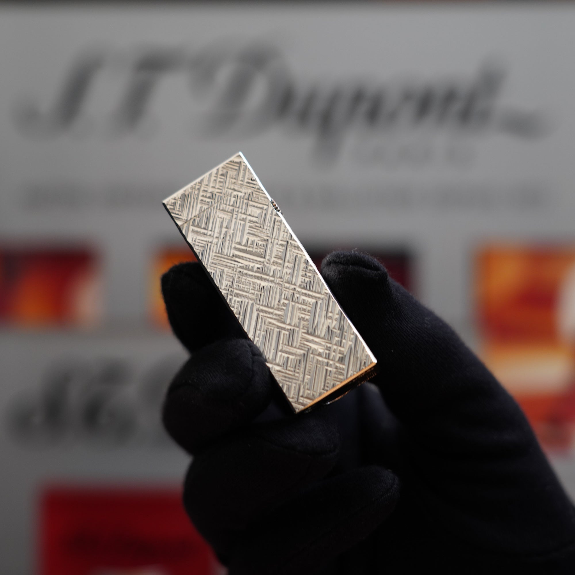 A person is holding a vintage 1980 Dunhill Rollagas Silver Plated Florentine Pattern lighter, a collector's item.