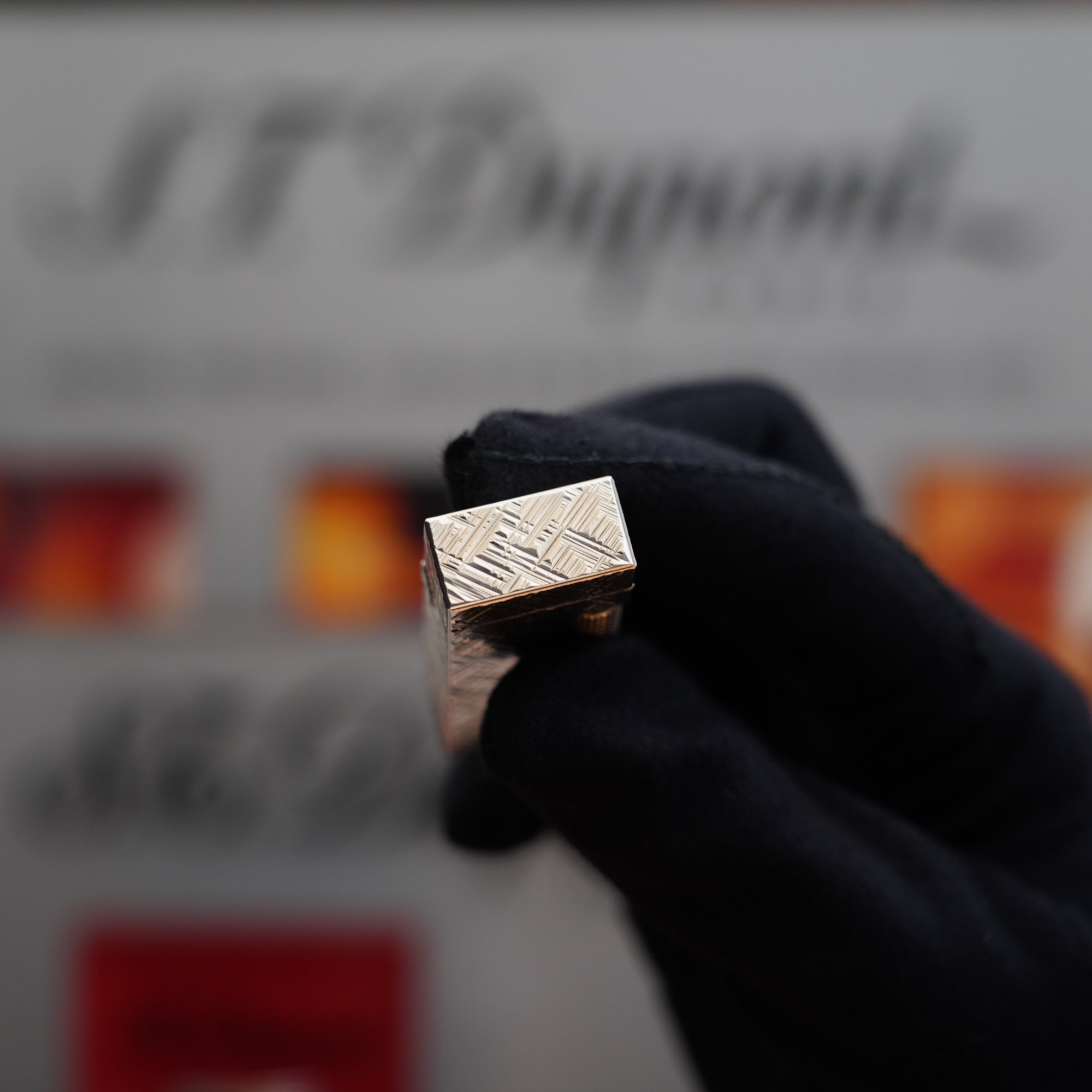 A person is holding a Vintage 1980 Dunhill Rollagas Silver Plated Florentine Pattern Lighter, a collector's item.