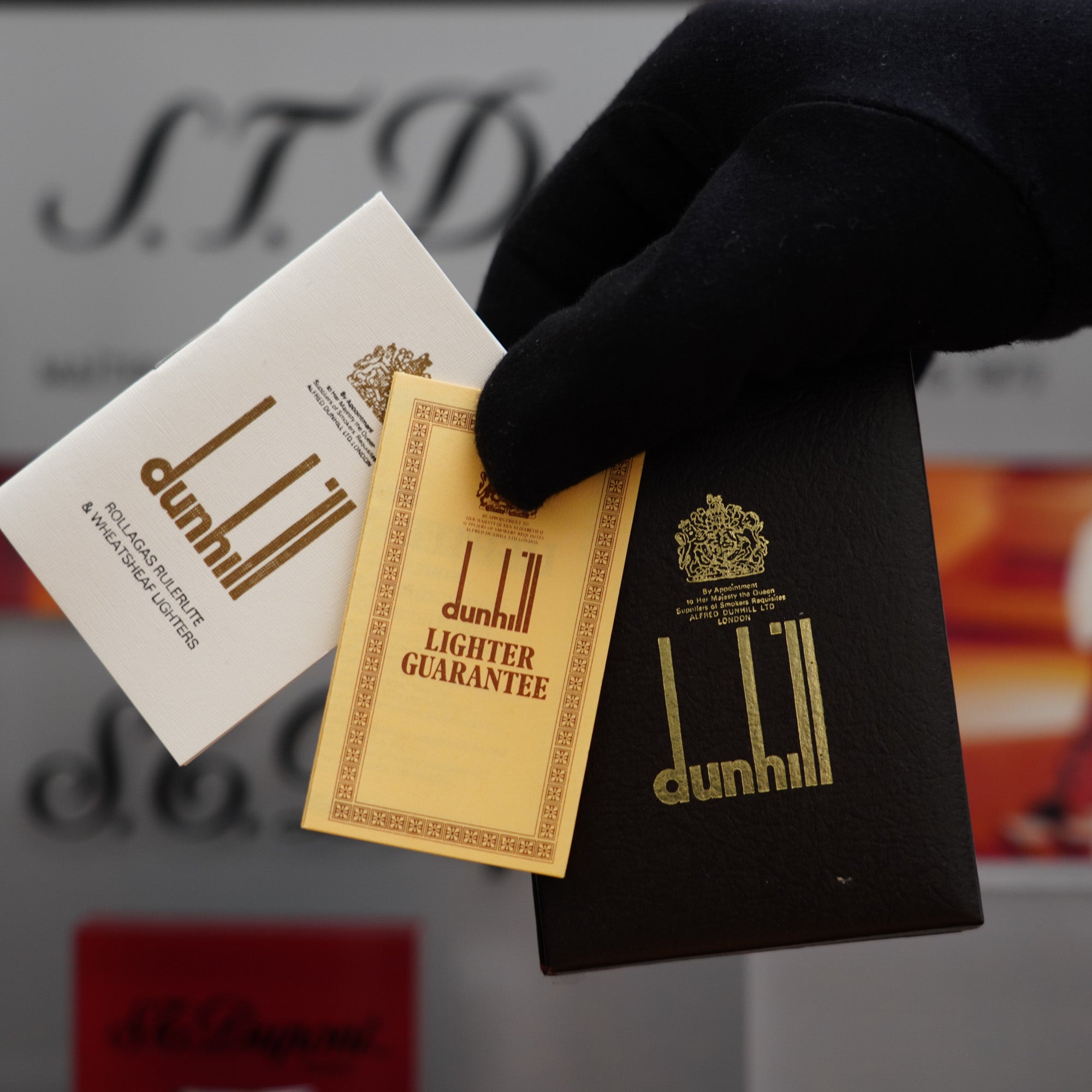 A person is holding a box of Vintage 1980 Dunhill Rollagas Silver Plated Florentine Pattern Lighter cigars, a collector's item.