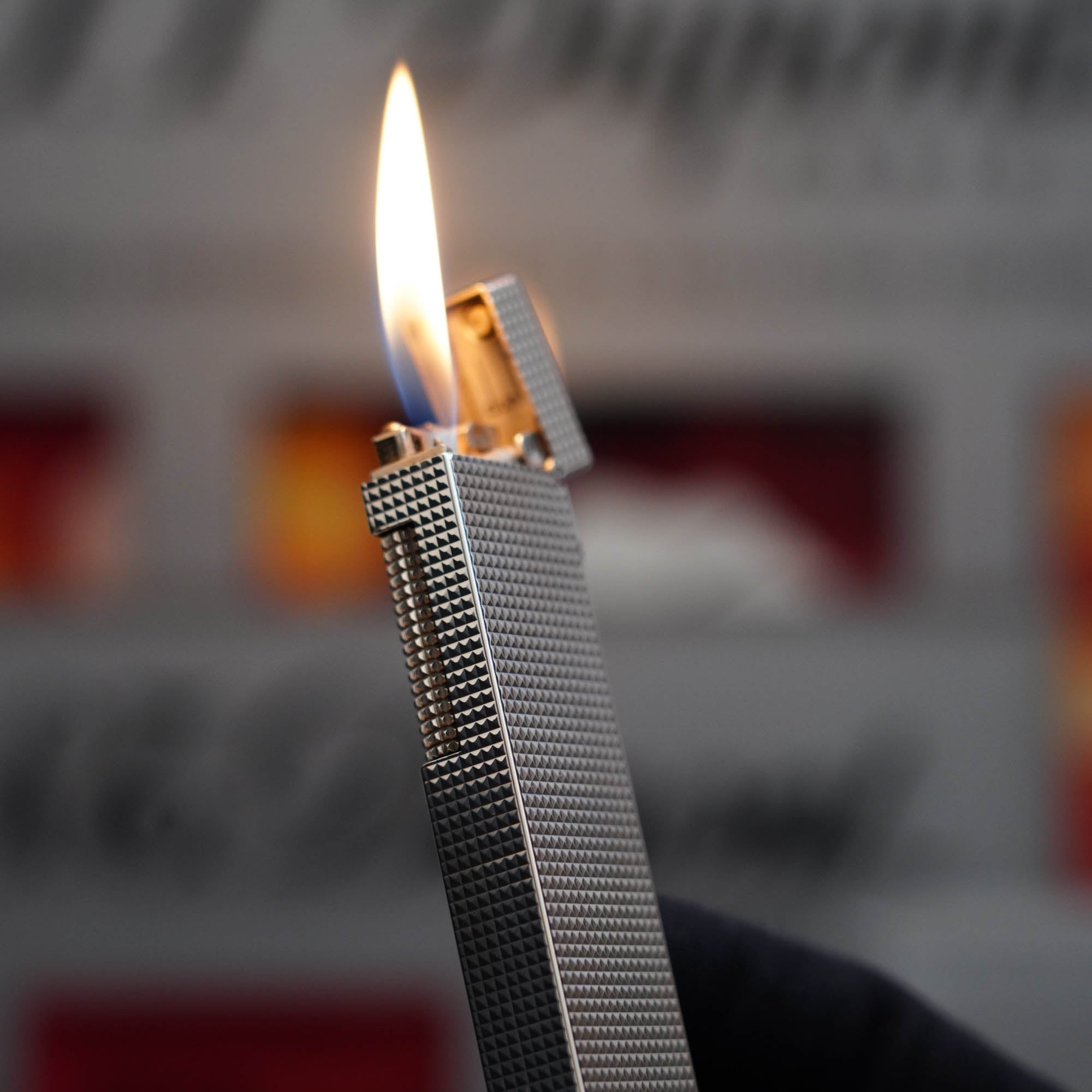 A vintage Dunhill table lighter, the Vintage 1970 Dunhill Table Lighter Diamond Head Silver Plated Long Boy Lighter, with a flame in it.