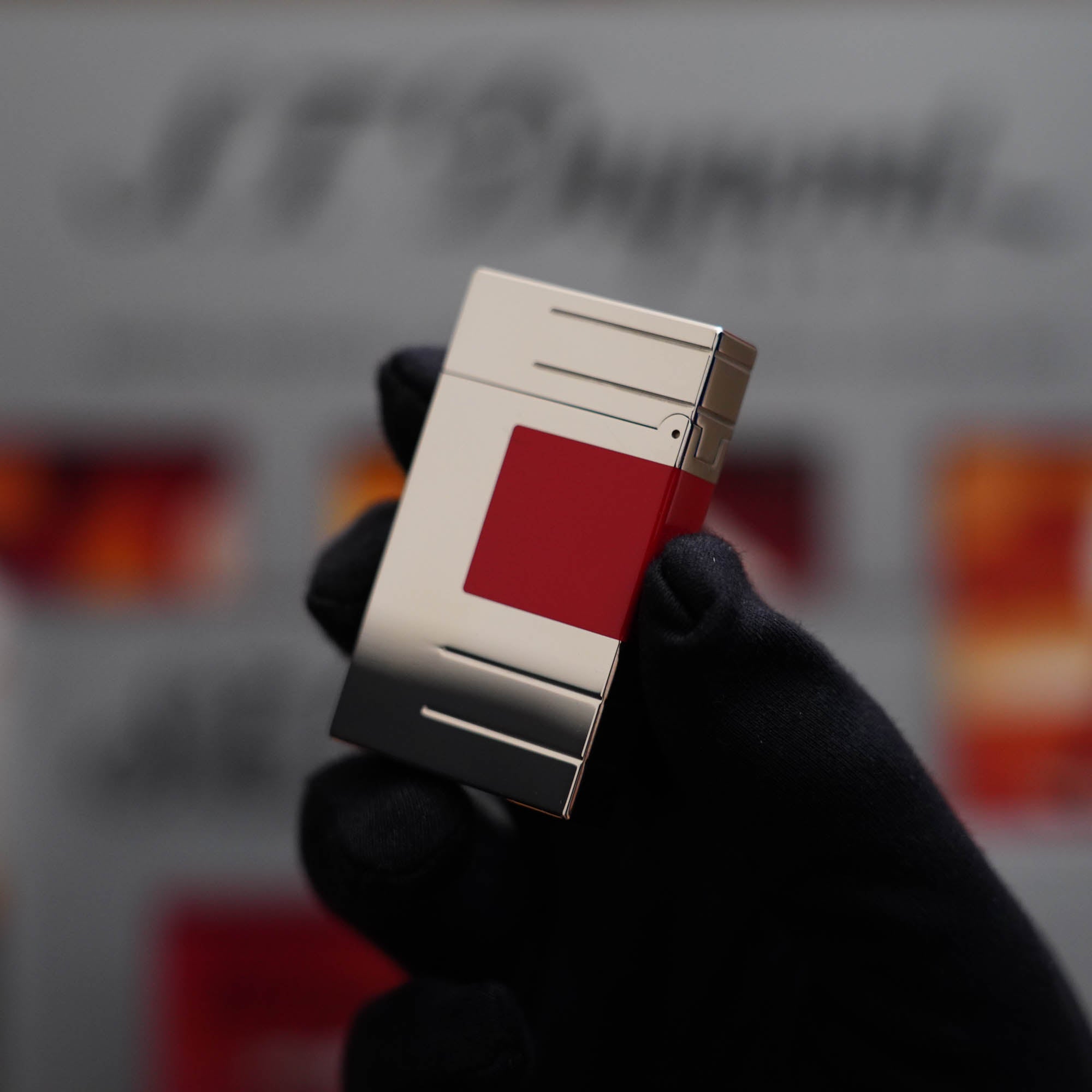 A vintage S.T. Dupont Ligne 2 Abstraction Red Laquer lighter being held up.