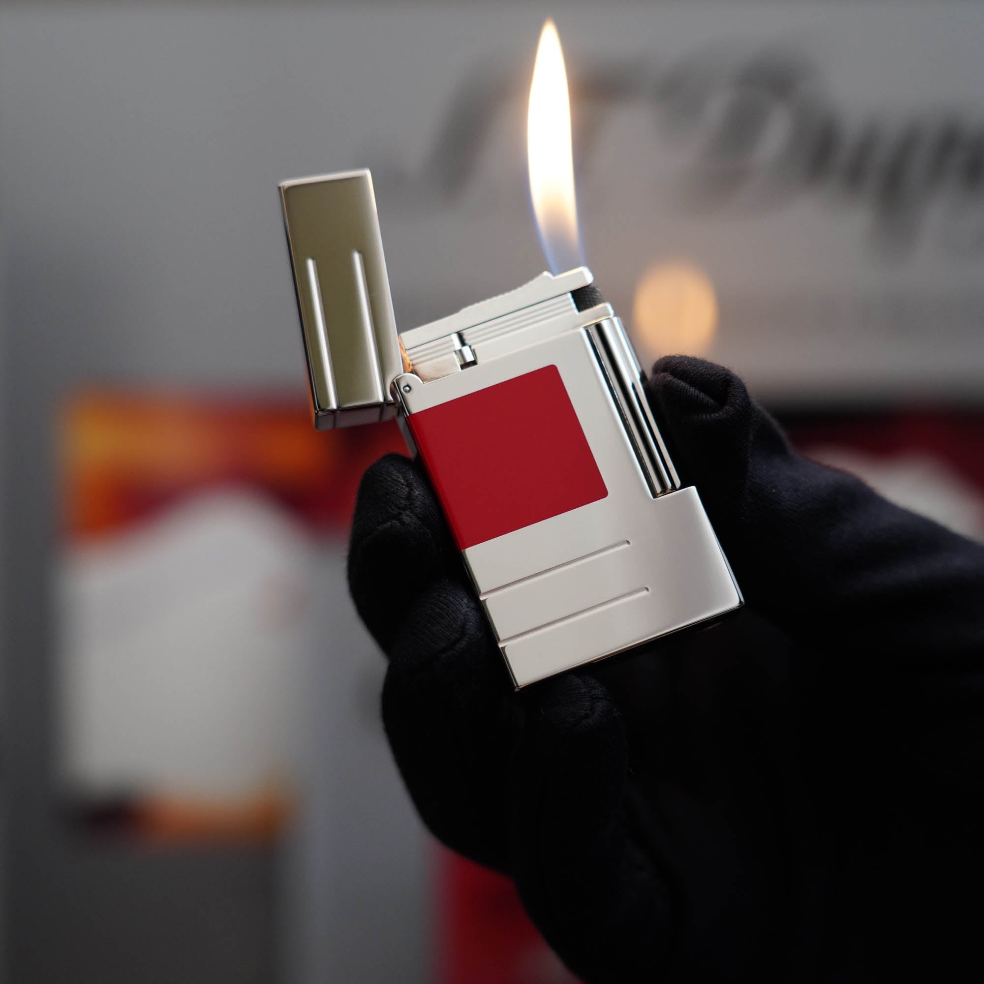 A vintage St Dupont Ligne 2 Abstraction Red Laquer Lighter with a red flame.