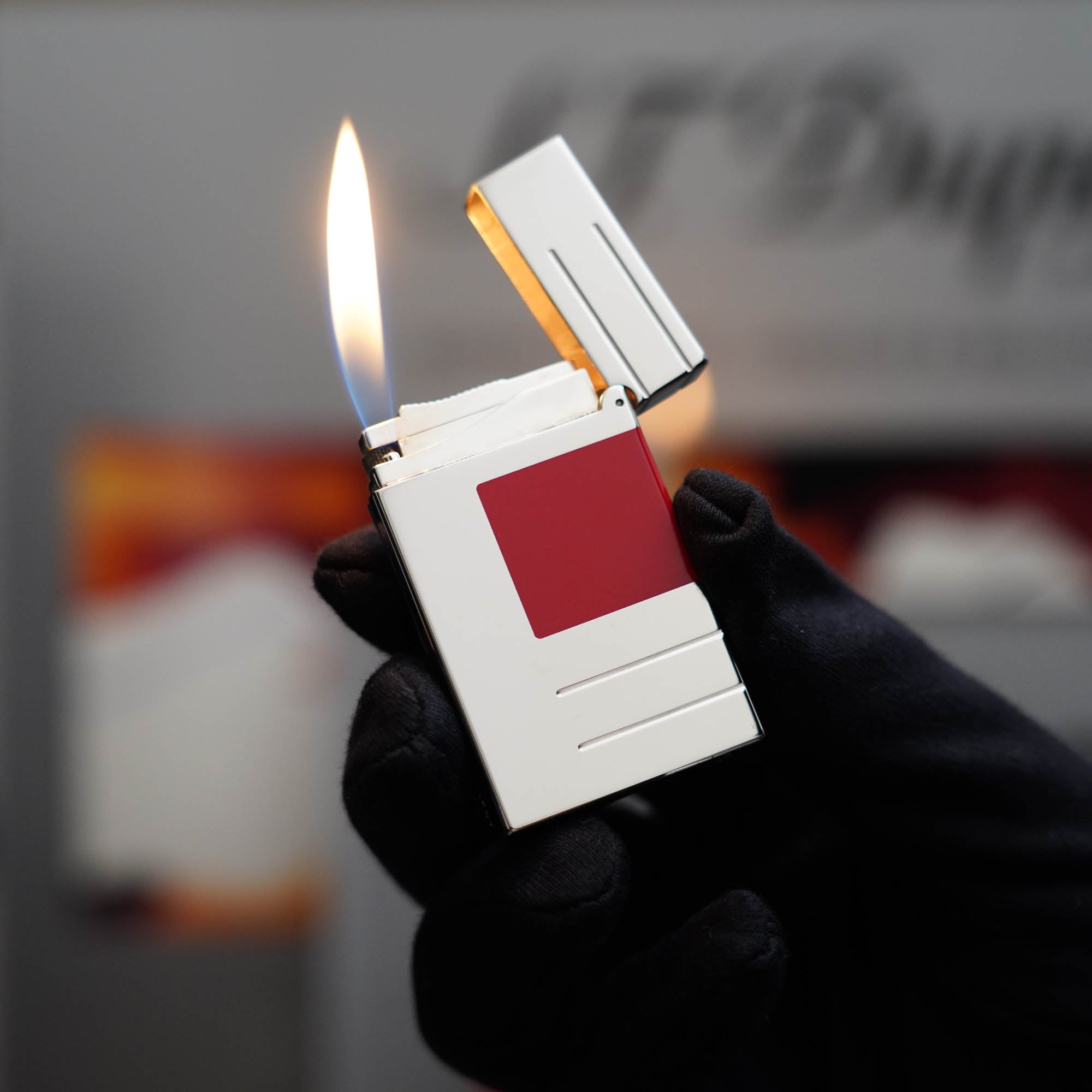 A vintage St Dupont Ligne 2 lighter with a red and white stripe has been replaced with a Vintage 1990 Limited Heavy Palladium Finish St Dupont Ligne 2 Abstraction Red Laquer Lighter by S.T. Dupont.