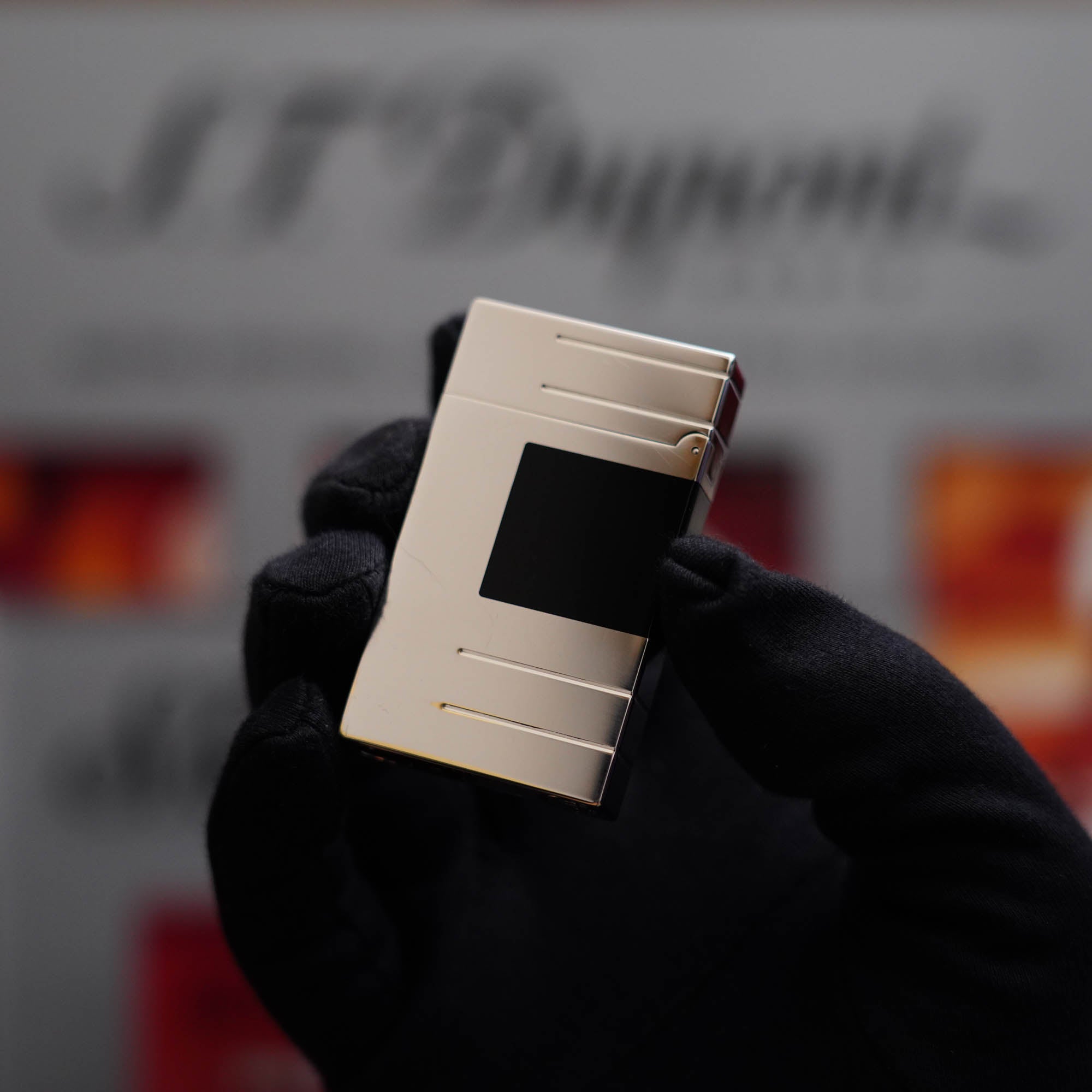 A vintage collector's item, the Vintage 1990 Limited Heavy Palladium Finish S.T. Dupont Ligne 2 Abstraction Black Laquer Lighter is held by a person.